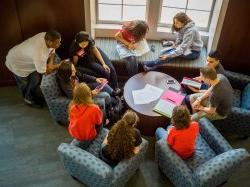 Group of students studying together around table.